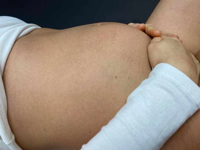 Primo piano dell'addome di una donna con le mani appoggiate sulla pancia, riferimento alla riabilitazione della diastasi dei retti addominali nel post-parto a Vibo Valentia